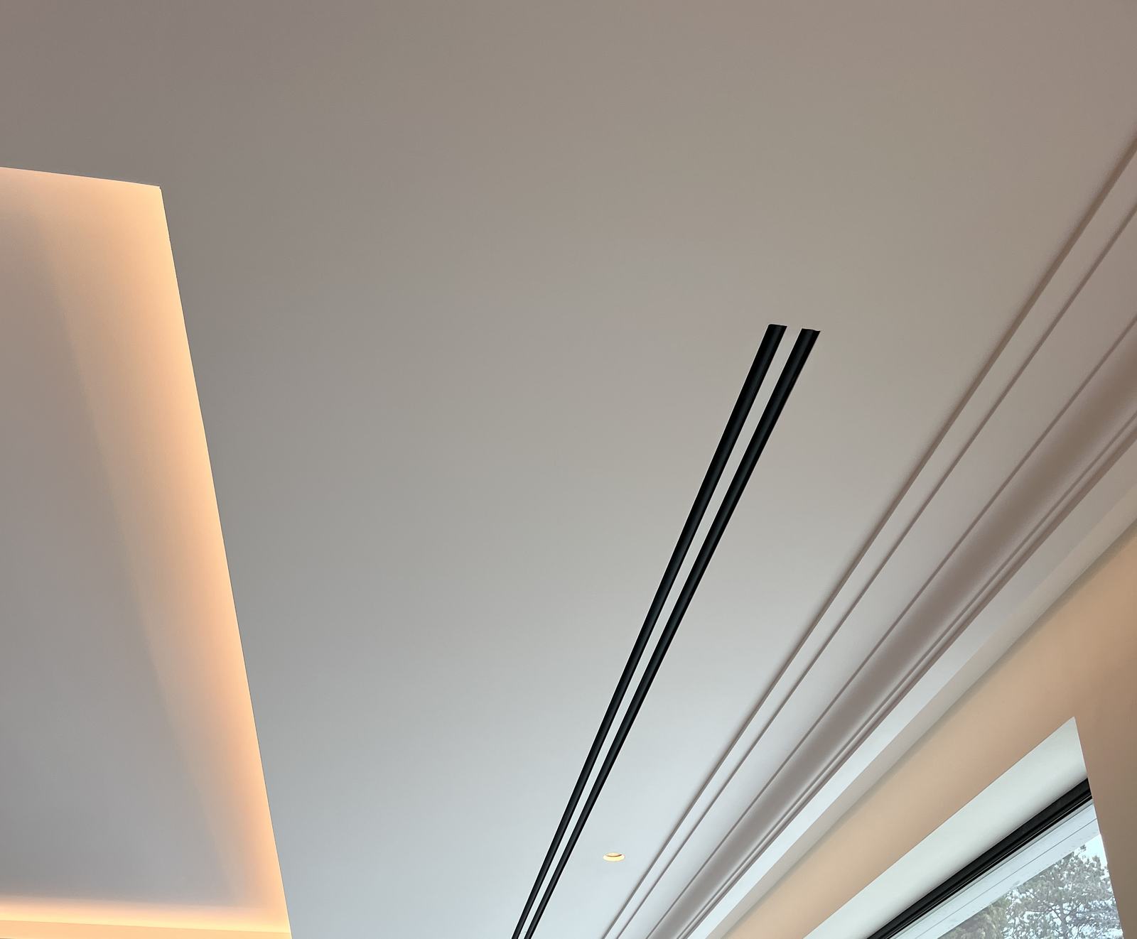 Black linear slot diffusers running flush along a glazed elevation