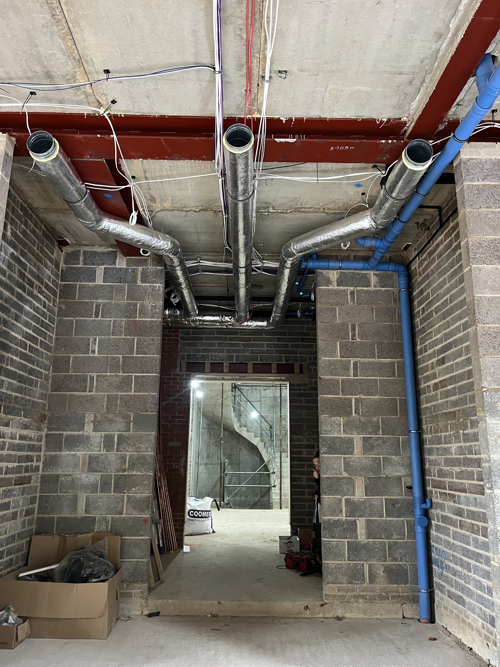 Spiral ductwork routed through a commercial basement at first fix