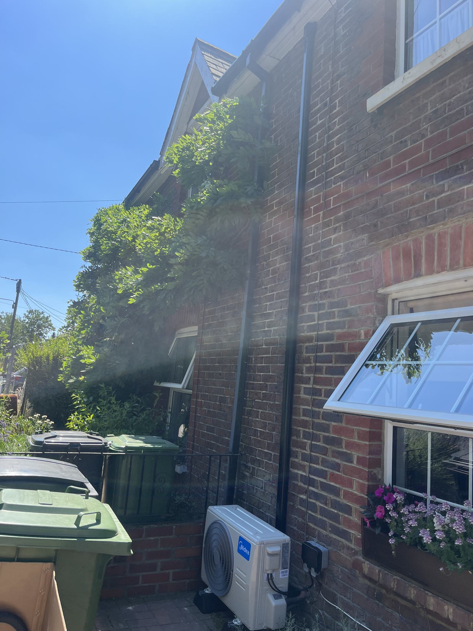 External condenser unit and line covers installed on a brick elevation