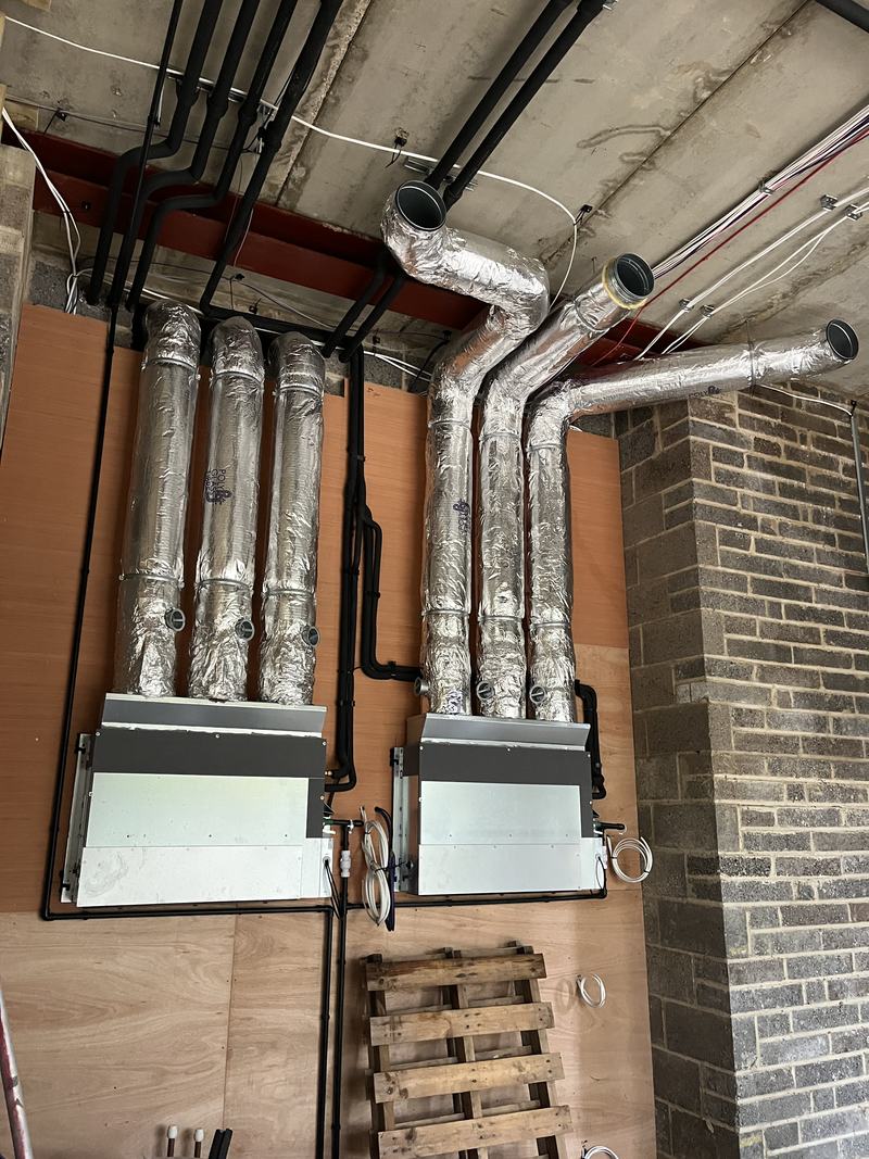 Ceiling fan coil units and insulated flexible ductwork installed at first fix