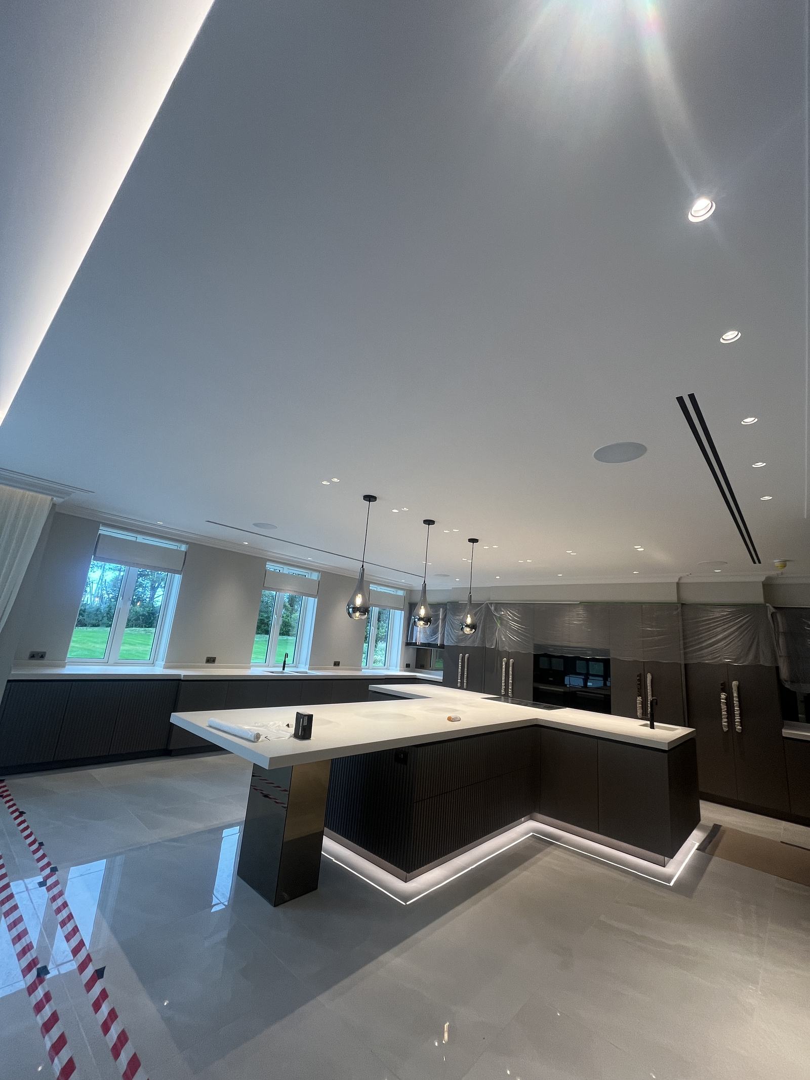 Open-plan kitchen with linear slot diffusers set flush into the ceiling