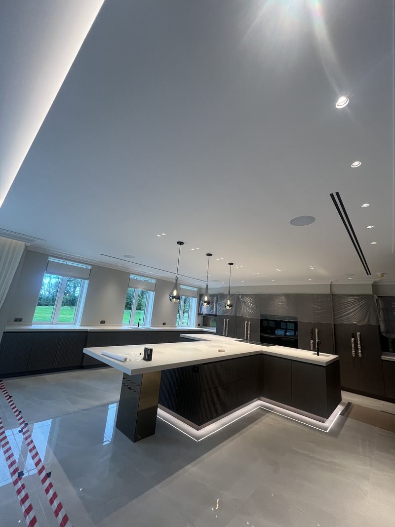 Open-plan kitchen with linear slot diffusers set flush into the ceiling